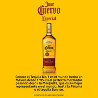  Botella de tequila reposado José Cuervo junto a un vaso que contiene un coctel de color rosado, para ilustrar la receta de una Paloma. 